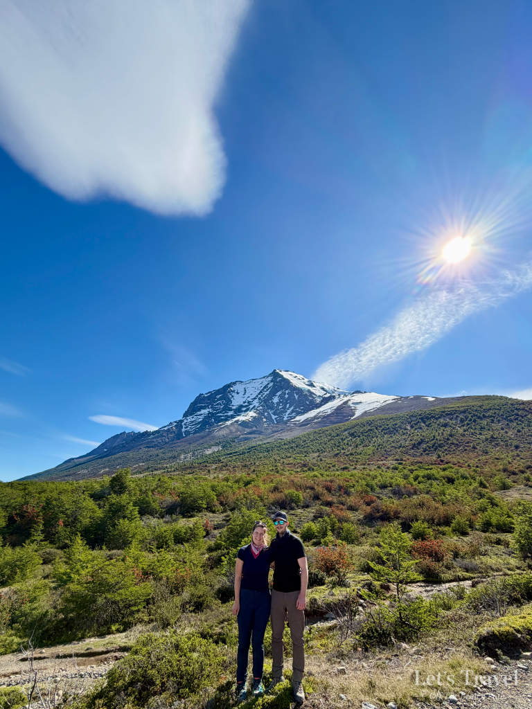 Couple in Torres del Paine National Park Chile Patagonia with snow capped mountain and blue sky