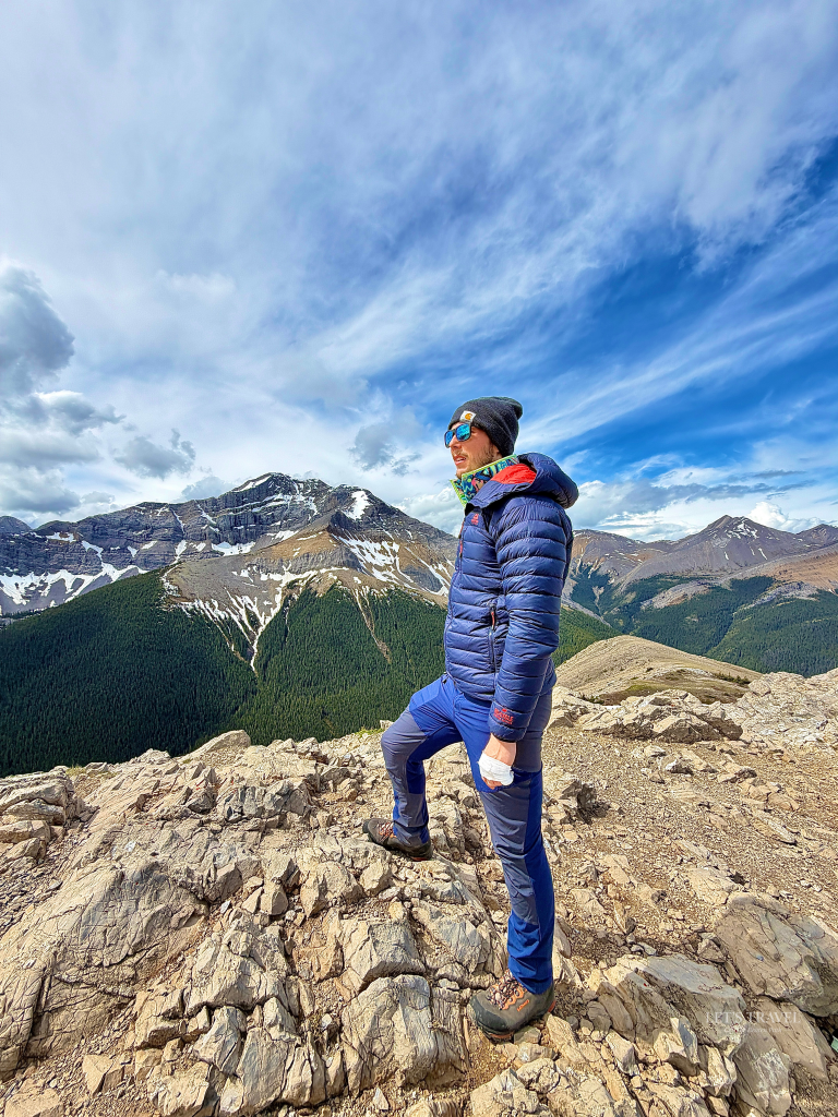Hiker standing on the summit of the Sulphur Skyline Trail with panoramic mountain views in Jasper National Park, Alberta, Canada.