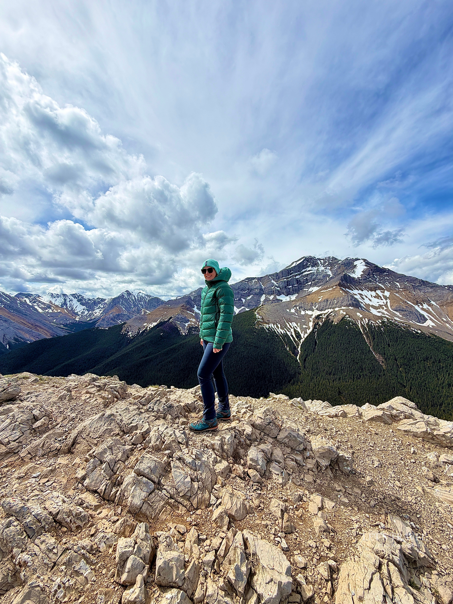 Hiker standing on the summit of the Sulphur Skyline Trail overlooking the Canadian Rockies in Jasper National Park, Alberta, Canada.
