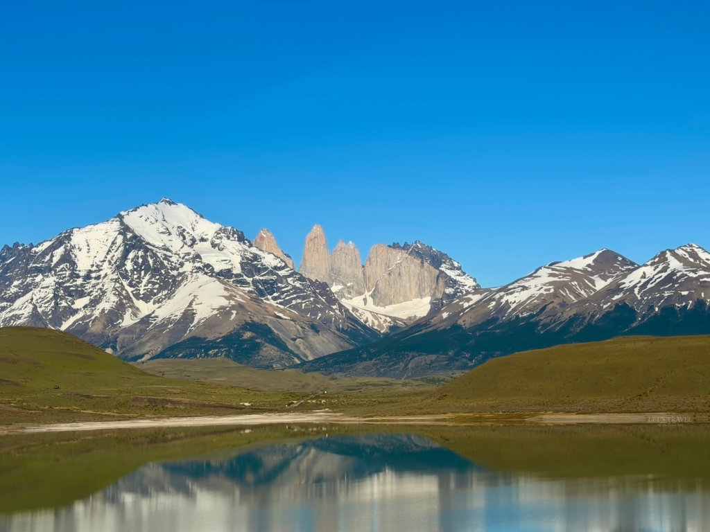 Panoramic view of the iconic Torres del Paine granite towers surrounded by snow-capped mountains in Torres del Paine National Park, Chilean Patagonia.