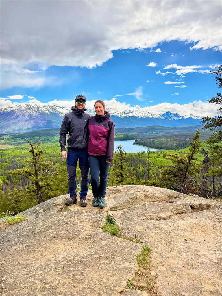 Couple standing at Pyramid Bench viewpoint overlooking Pyramid Lake and the Canadian Rockies in Jasper National Park, Canada.