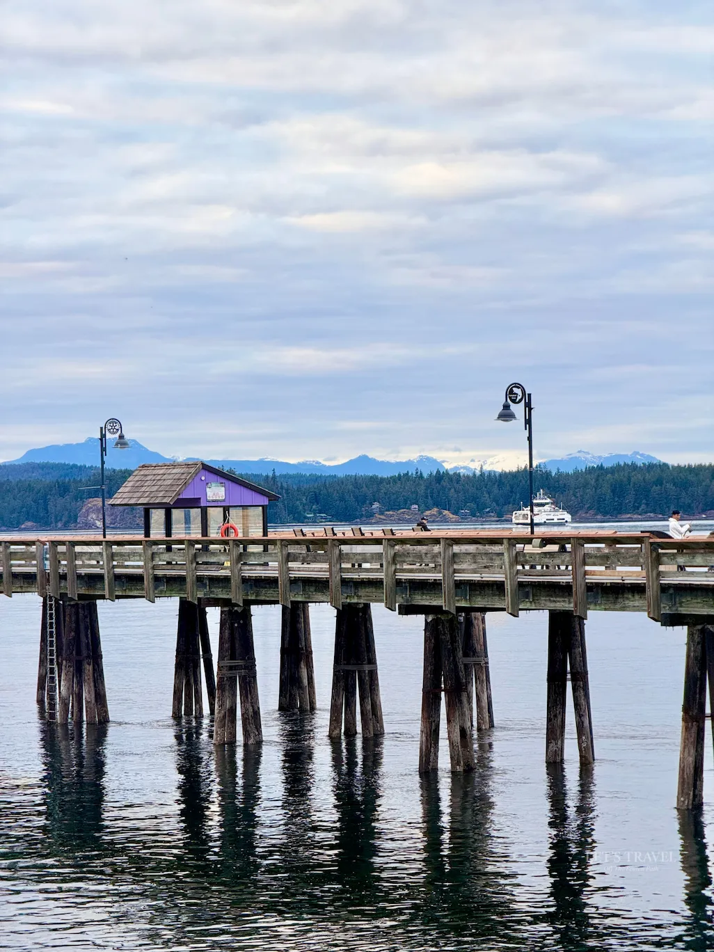 Man relaxing on a wooden pier at Campbell River waterfront on Vancouver Island, British Columbia, overlooking the ocean.