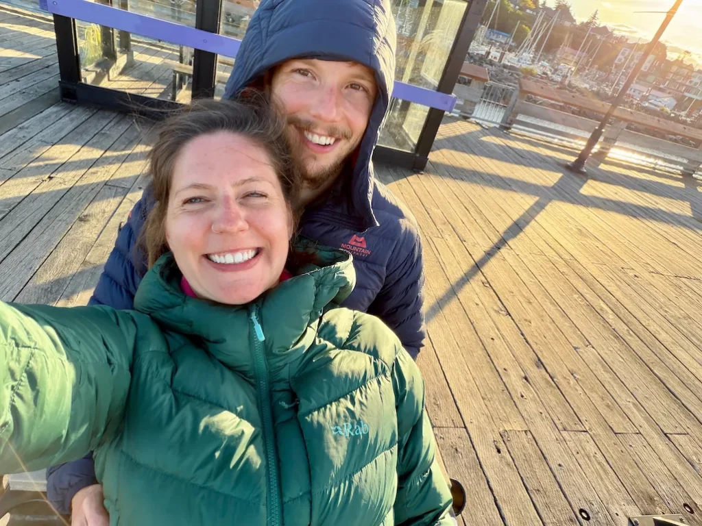 Couple taking a selfie on the wooden waterfront boardwalk at Campbell River Harbour on Vancouver Island, British Columbia.