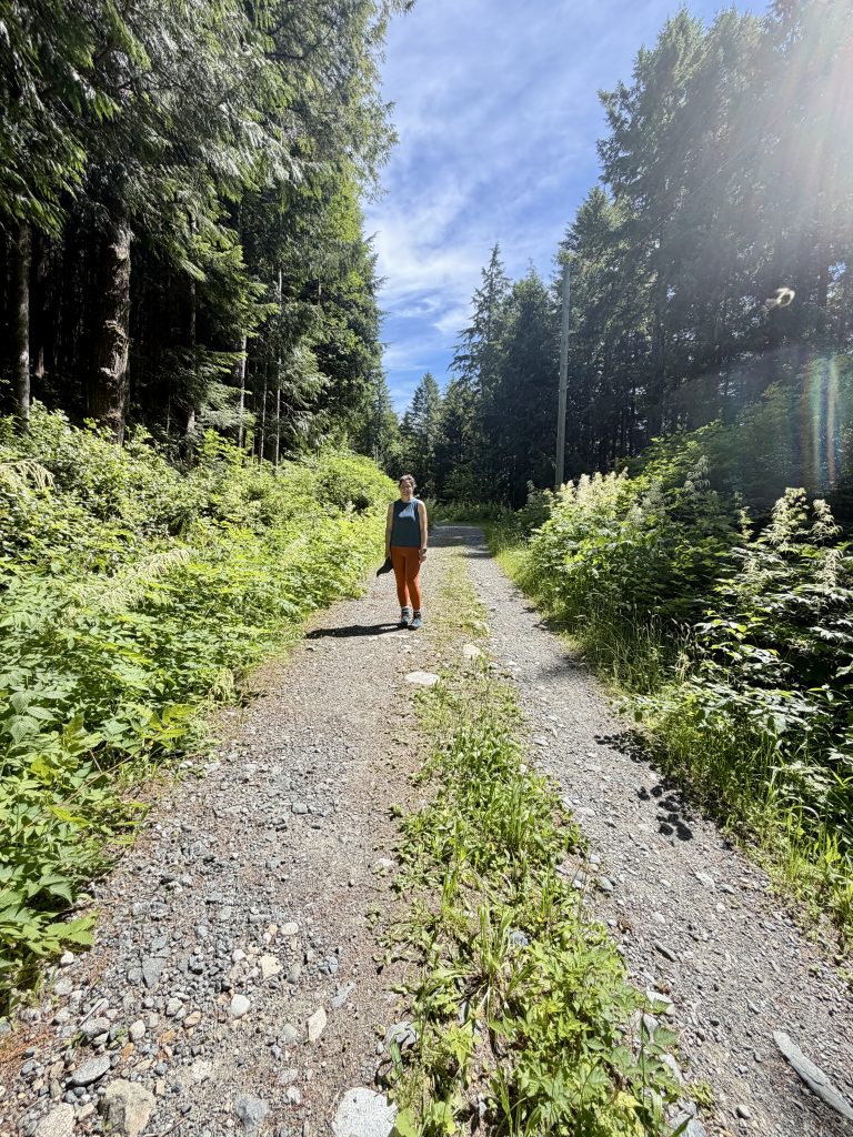 Hiker walking along a rocky forest trail on the way to Mount Ozzard on Vancouver Island, British Columbia.